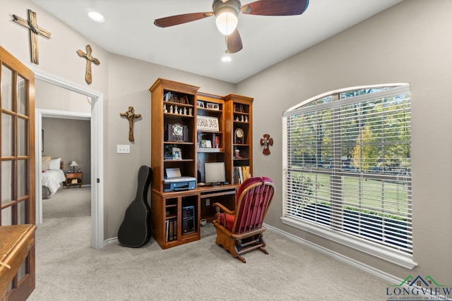 carpeted office space featuring ceiling fan