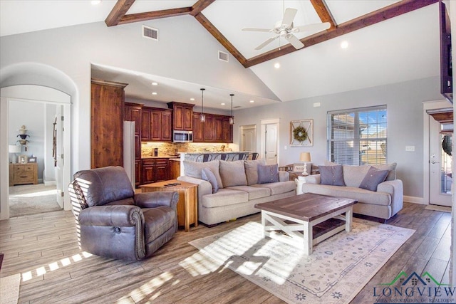 living room with beam ceiling, ceiling fan, high vaulted ceiling, and light hardwood / wood-style floors