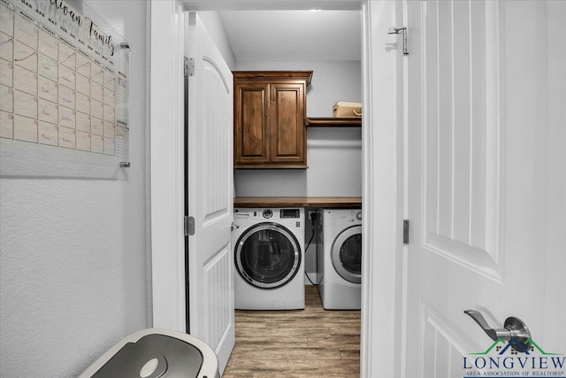 laundry room with separate washer and dryer, light hardwood / wood-style flooring, and cabinets