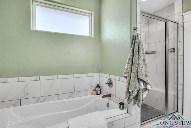 bathroom featuring shower with separate bathtub