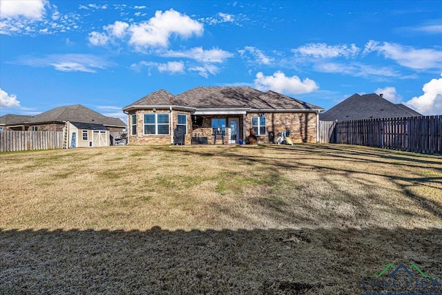 back of house featuring a yard and a storage shed