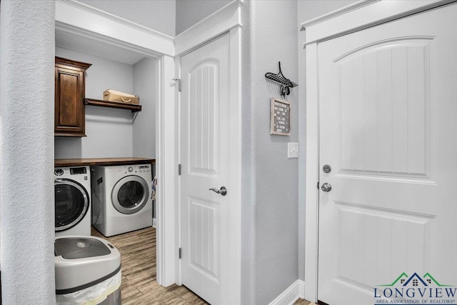 clothes washing area with light wood-type flooring and washing machine and clothes dryer