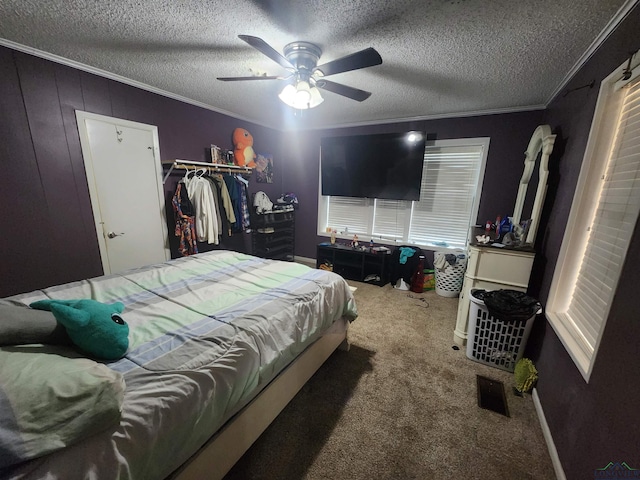 carpeted bedroom with ceiling fan, a closet, crown molding, and a textured ceiling