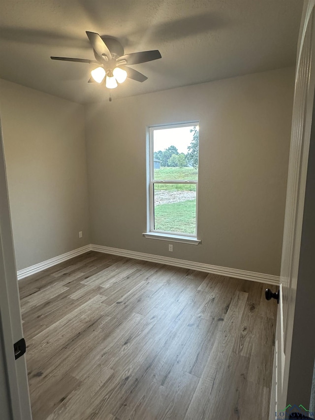 empty room with ceiling fan and light wood-type flooring