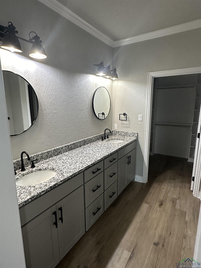 bathroom featuring crown molding, hardwood / wood-style floors, and vanity