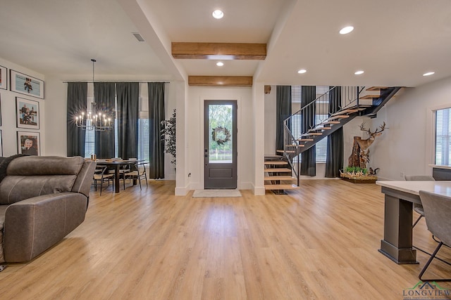 foyer with beamed ceiling, a notable chandelier, and light wood-type flooring