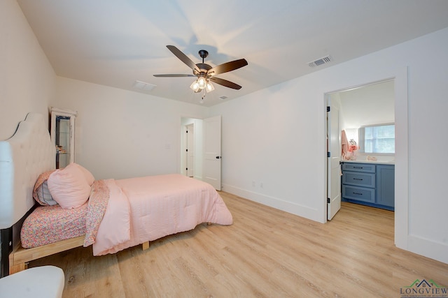 bedroom featuring light wood-type flooring, ceiling fan, and connected bathroom