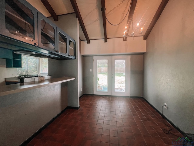 kitchen with french doors, vaulted ceiling with beams, an inviting chandelier, and a healthy amount of sunlight