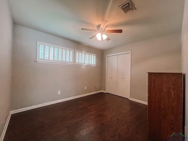 unfurnished bedroom featuring ceiling fan, dark hardwood / wood-style flooring, and a closet