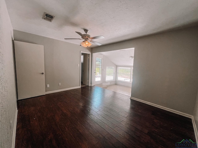 empty room featuring lofted ceiling, hardwood / wood-style floors, ceiling fan, and a textured ceiling