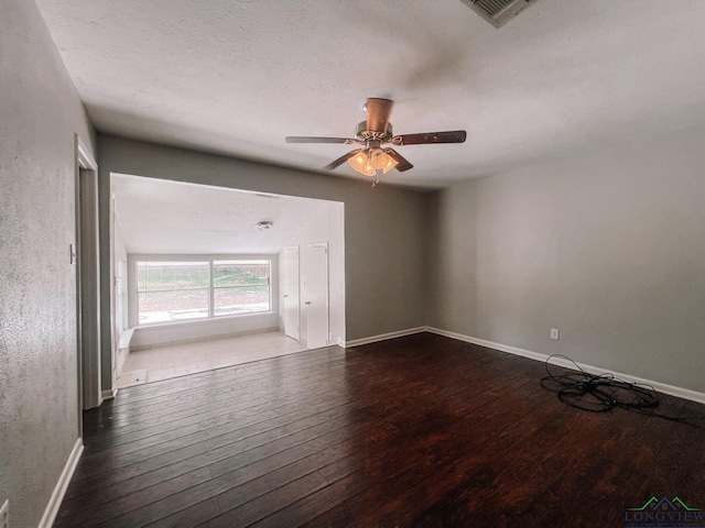 empty room with ceiling fan, a textured ceiling, and hardwood / wood-style flooring