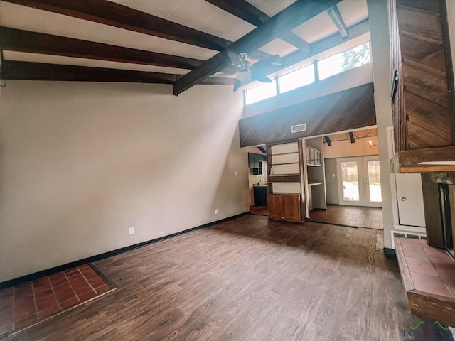 unfurnished living room featuring dark hardwood / wood-style flooring, french doors, beamed ceiling, and a towering ceiling