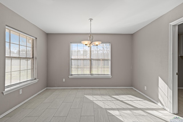 unfurnished dining area with an inviting chandelier