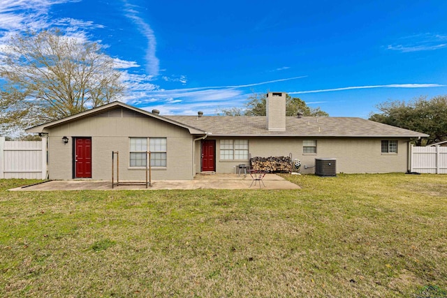 rear view of property featuring a patio area, a lawn, and central AC