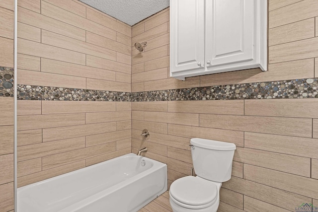 bathroom featuring toilet, a textured ceiling, and washtub / shower combination