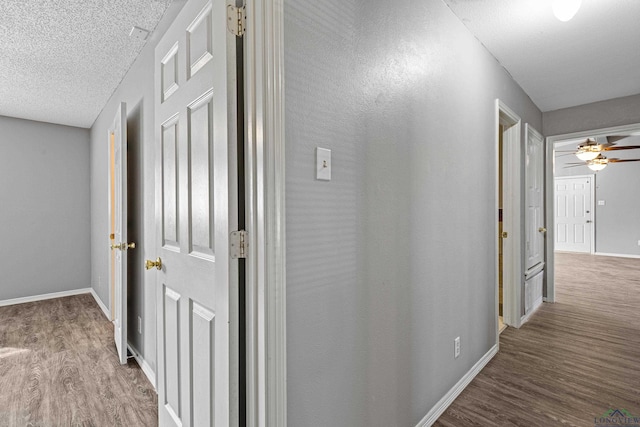 hall featuring a textured ceiling and wood-type flooring