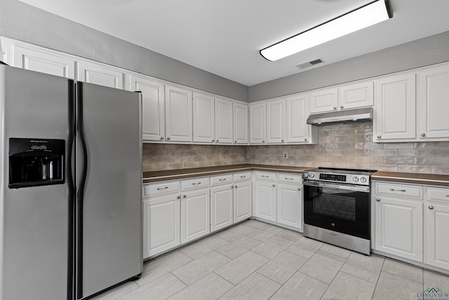 kitchen featuring light tile patterned floors, stainless steel appliances, white cabinetry, and tasteful backsplash