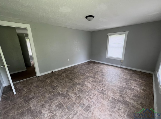 unfurnished room featuring a textured ceiling