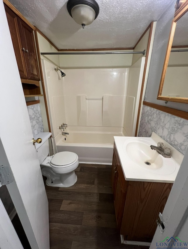 full bathroom featuring vanity, hardwood / wood-style flooring, toilet, a textured ceiling, and tub / shower combination