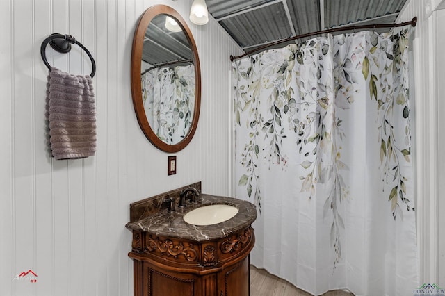 bathroom with wood-type flooring, curtained shower, and vanity