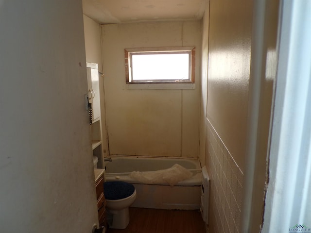 bathroom featuring a washtub, vanity, hardwood / wood-style floors, and toilet