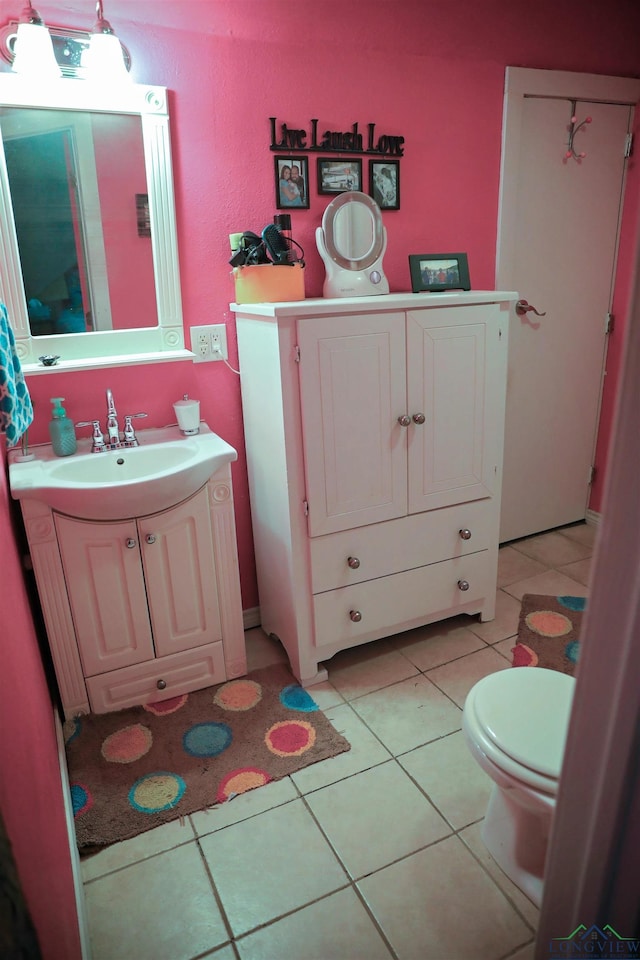 bathroom featuring tile patterned flooring, vanity, and toilet