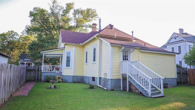 rear view of property with a yard