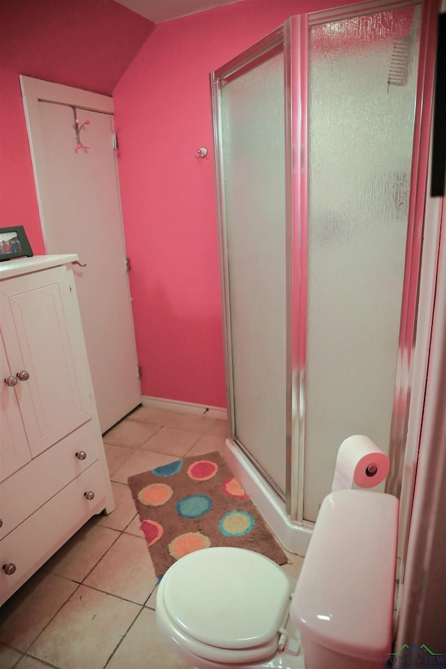 bathroom featuring tile patterned floors, toilet, and a shower with door