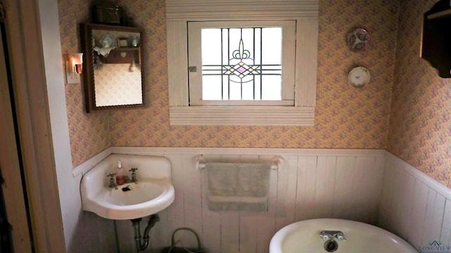 bathroom featuring sink and a tub to relax in