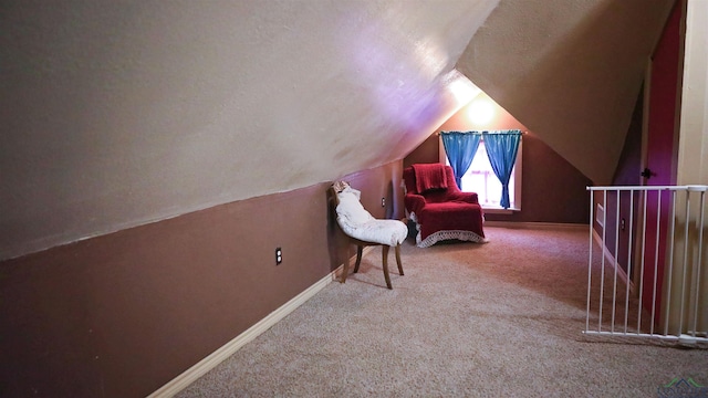 sitting room with a textured ceiling, carpet floors, and lofted ceiling