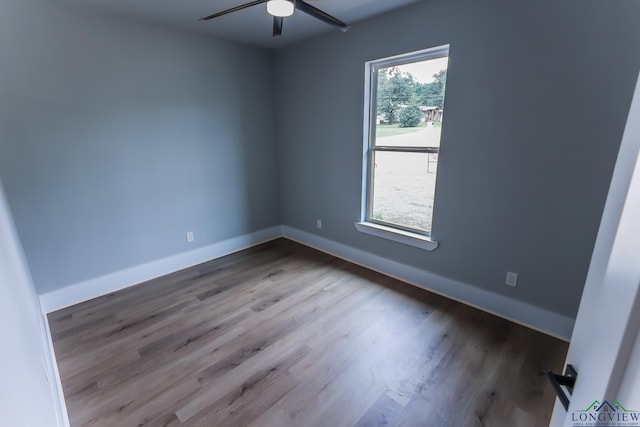 empty room with hardwood / wood-style floors, plenty of natural light, and ceiling fan