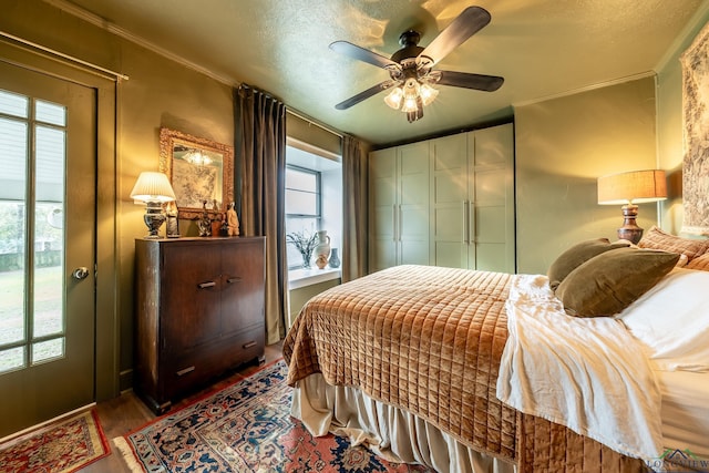 bedroom featuring access to exterior, ceiling fan, crown molding, and a textured ceiling