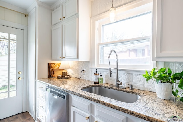 kitchen featuring a wealth of natural light, white cabinetry, dishwasher, and sink