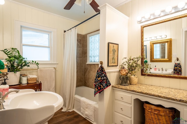 bathroom with wood-type flooring, shower / bathtub combination with curtain, crown molding, and sink