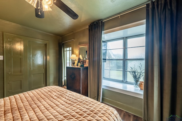 bedroom with hardwood / wood-style floors, ceiling fan, crown molding, and multiple windows