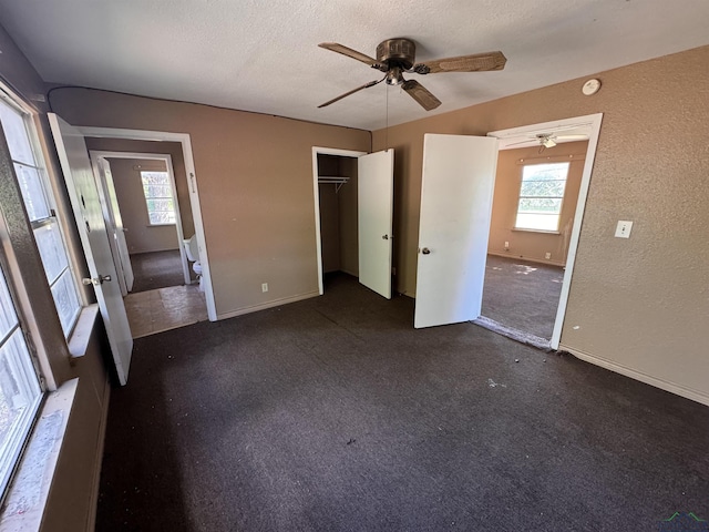 unfurnished bedroom with multiple windows, ceiling fan, a closet, and a textured ceiling