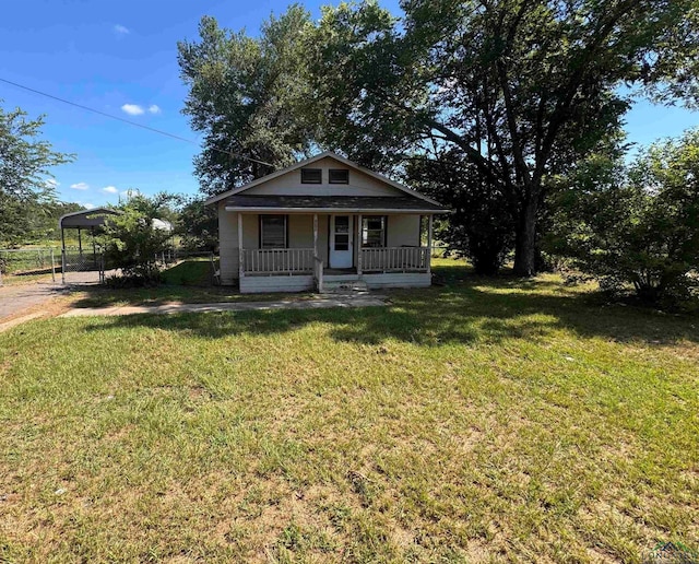 bungalow-style home with a front lawn, covered porch, and a carport