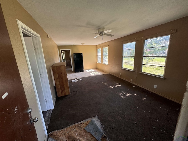 unfurnished living room featuring a textured ceiling and ceiling fan