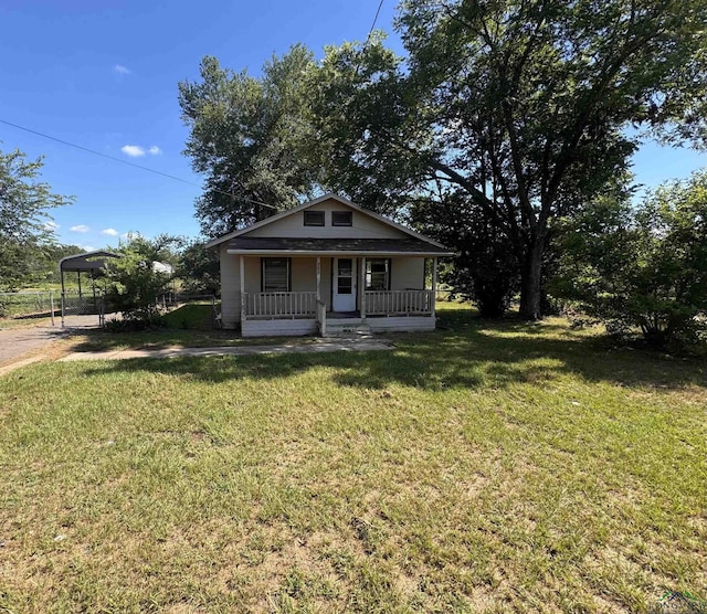 bungalow featuring a carport, covered porch, and a front yard