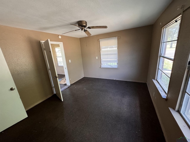 empty room with a textured ceiling, ceiling fan, and a healthy amount of sunlight