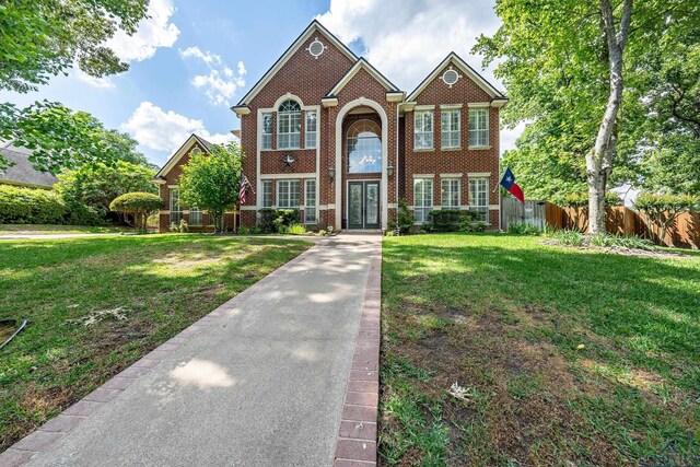 1303 Lesley, Longview, TX 75604 - view of front of home featuring fence, a front lawn, and brick siding