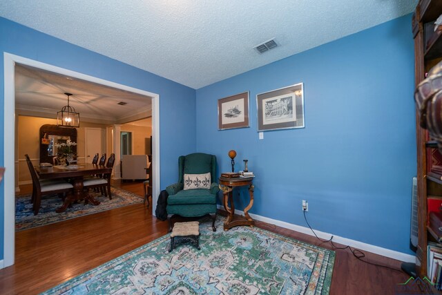 sitting room with hardwood / wood-style floors and a textured ceiling