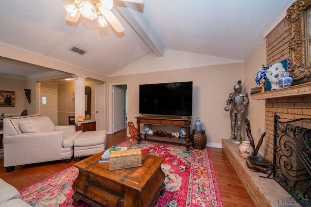 living room featuring lofted ceiling with beams, hardwood / wood-style flooring, a fireplace, and ceiling fan