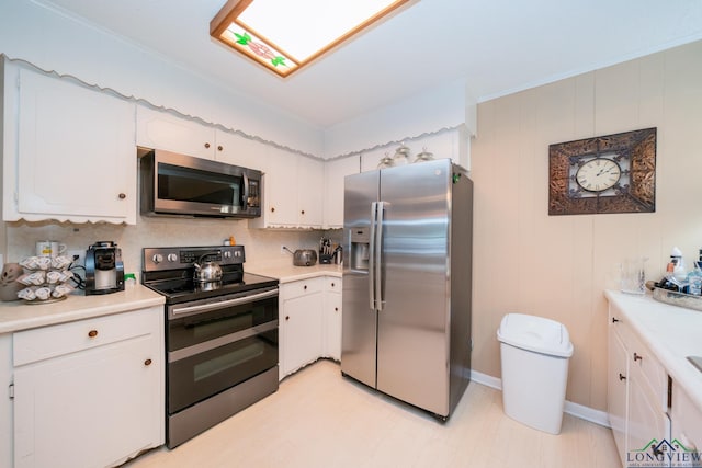 kitchen featuring backsplash, appliances with stainless steel finishes, crown molding, and white cabinets