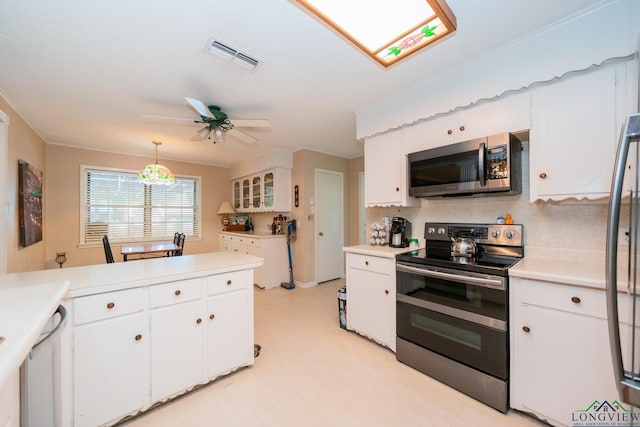 kitchen featuring pendant lighting, ceiling fan, appliances with stainless steel finishes, white cabinetry, and backsplash