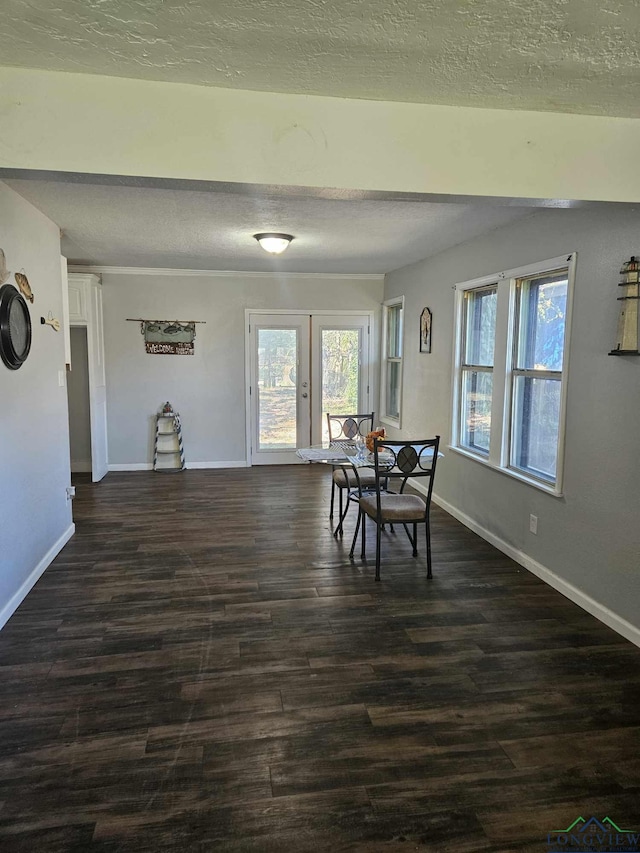 dining room with a textured ceiling and dark wood-type flooring