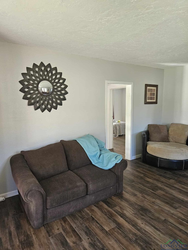 living room with dark hardwood / wood-style floors and a textured ceiling