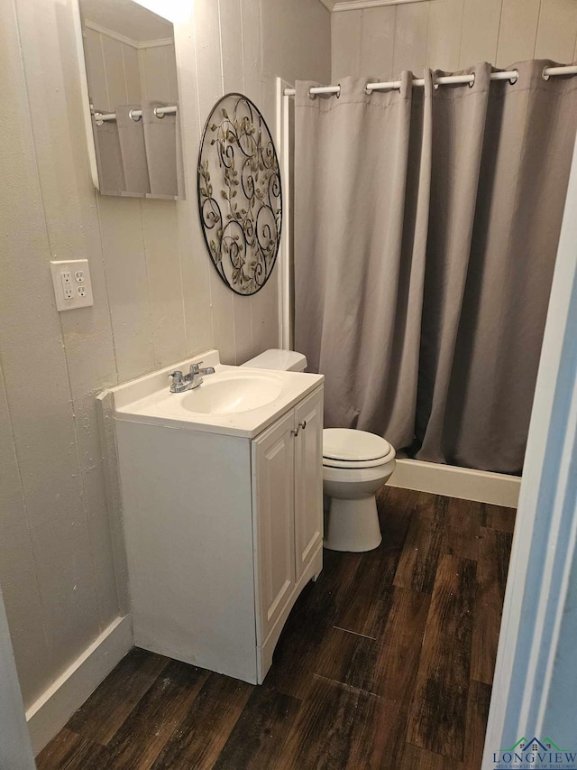 bathroom featuring toilet, vanity, wood-type flooring, and walk in shower