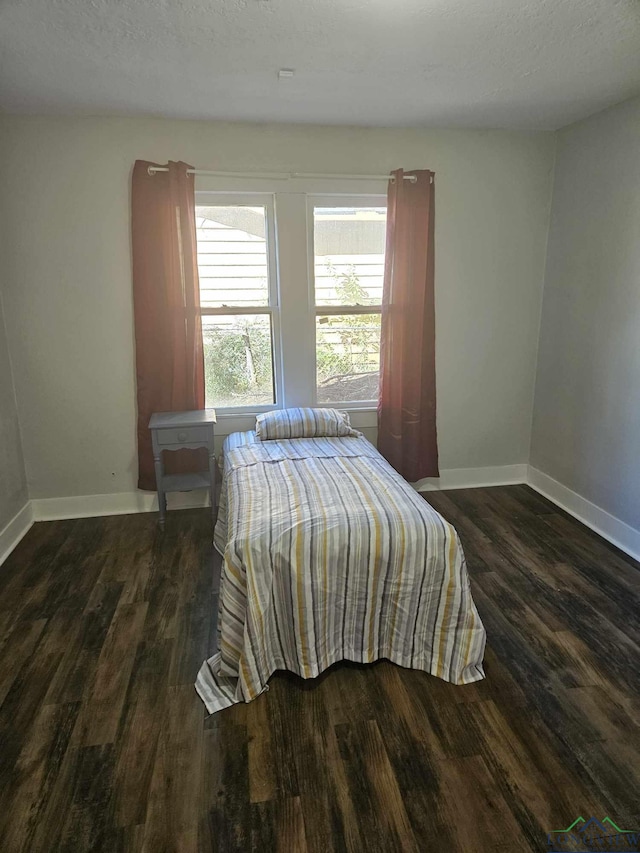 bedroom featuring dark hardwood / wood-style floors and a textured ceiling