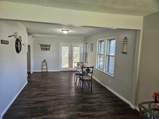 dining room with a textured ceiling, french doors, and dark hardwood / wood-style floors